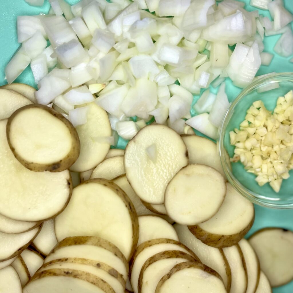 a pic of sliced potatoes, diced onion, minced garlic