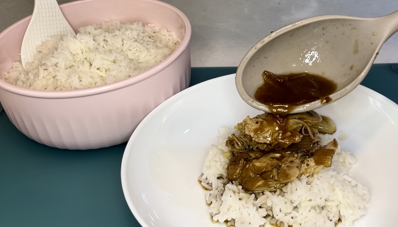 cooked chicken adobo over rice in a meal bowl