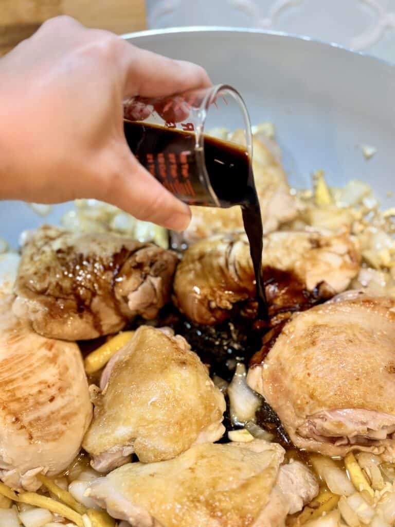 Chicken and garlic skillet with soy sauce, highlighting a savory cooking process.