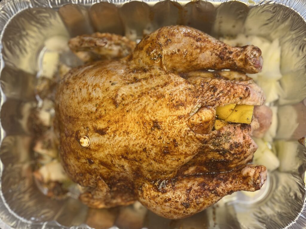 Whole chicken with oil and seasoning in a roasting pan