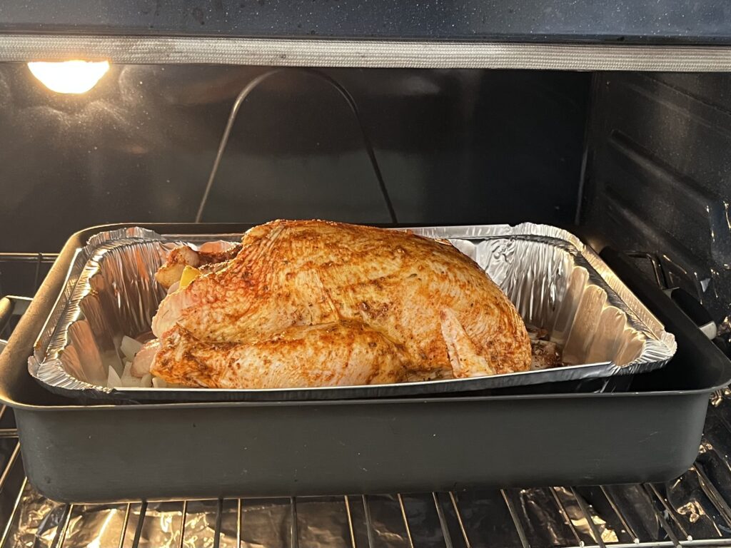 Raw whole chicken in a roasting pan in the oven