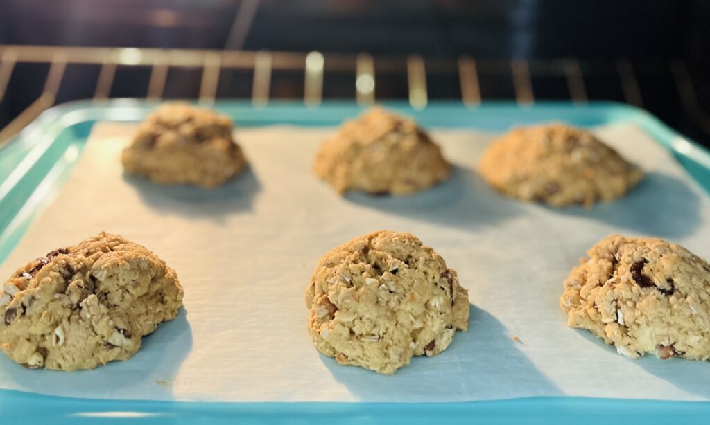 Cookies baking in oven on a lined baking sheet
