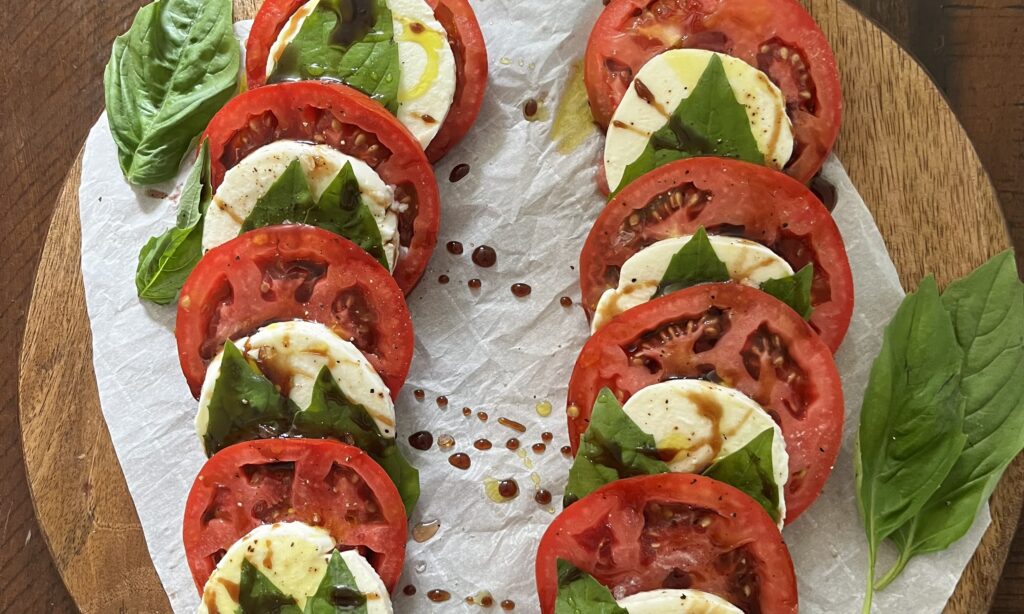 Caprese salad with olive oil and balsamic glaze on a cutting board 

