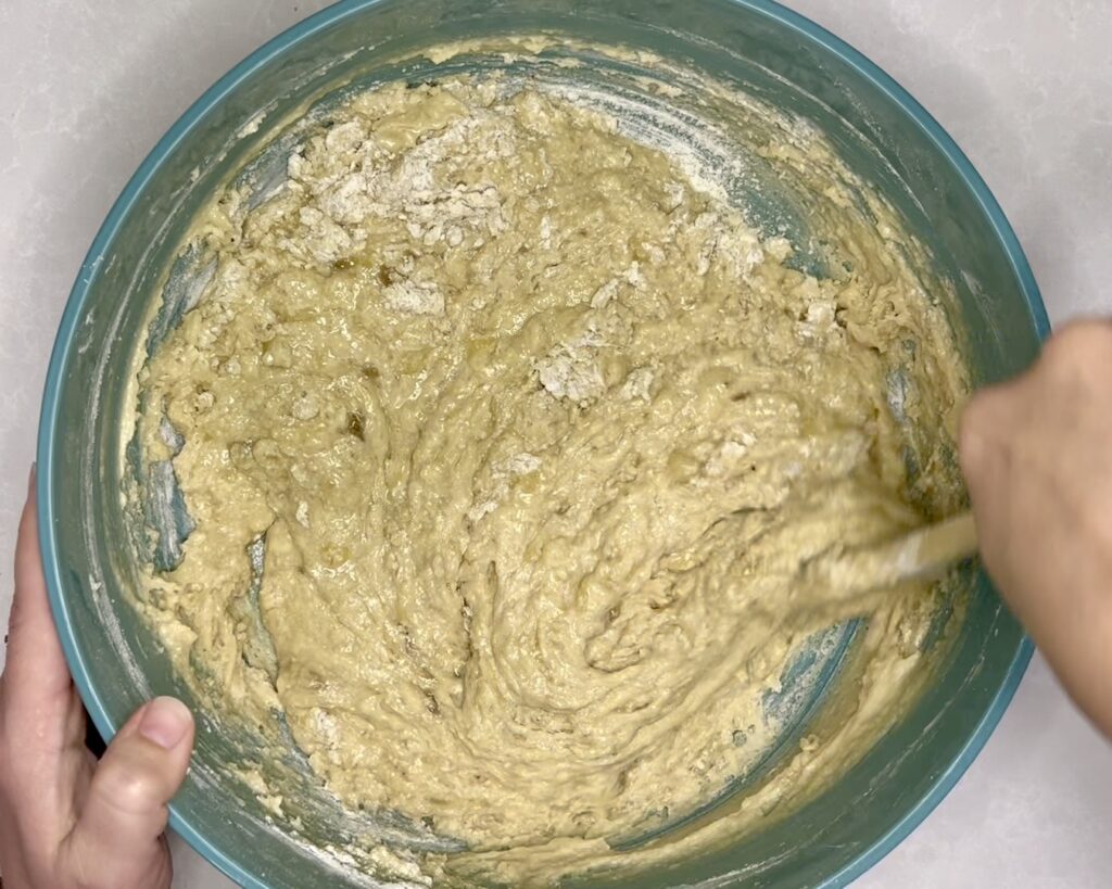 flour and bread batter being strred together 