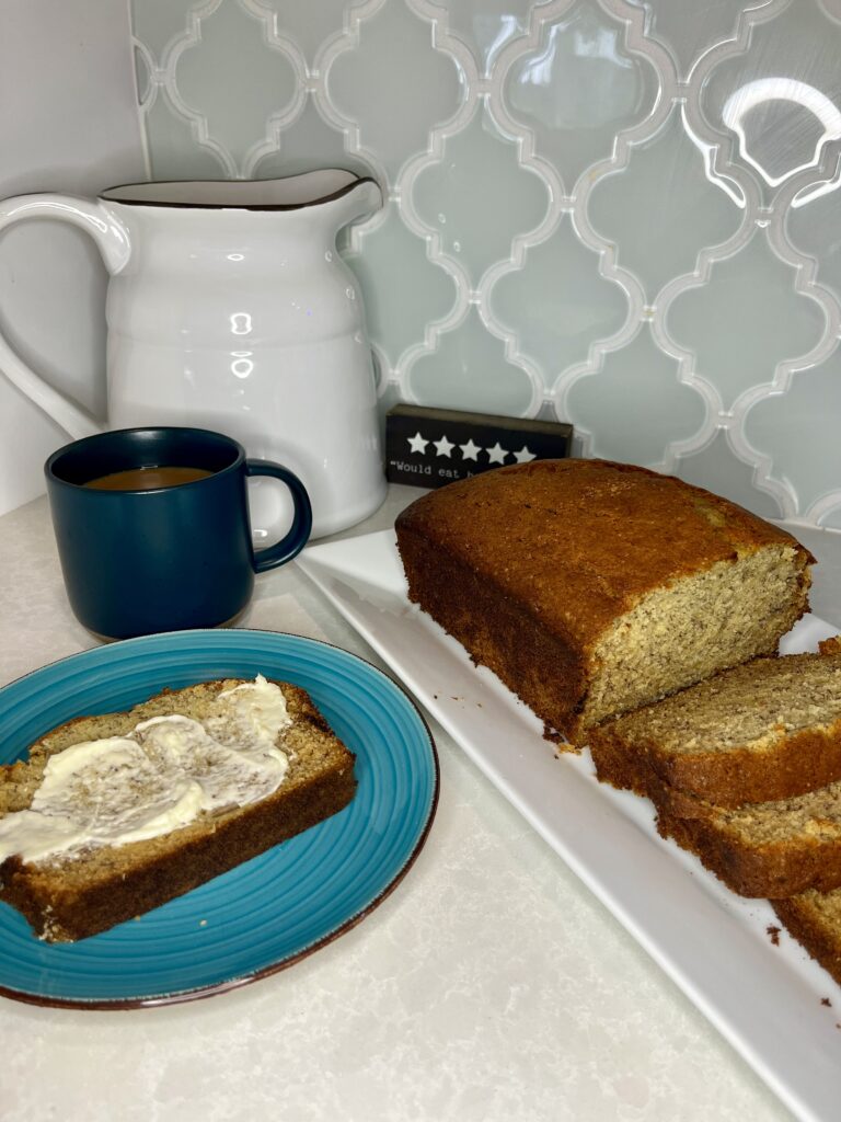 sliced banana bread with butter and a cup of coffee