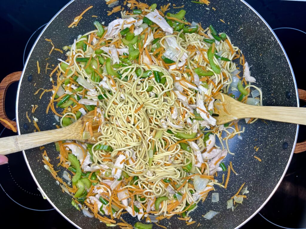 pancit canton noodles added to pot