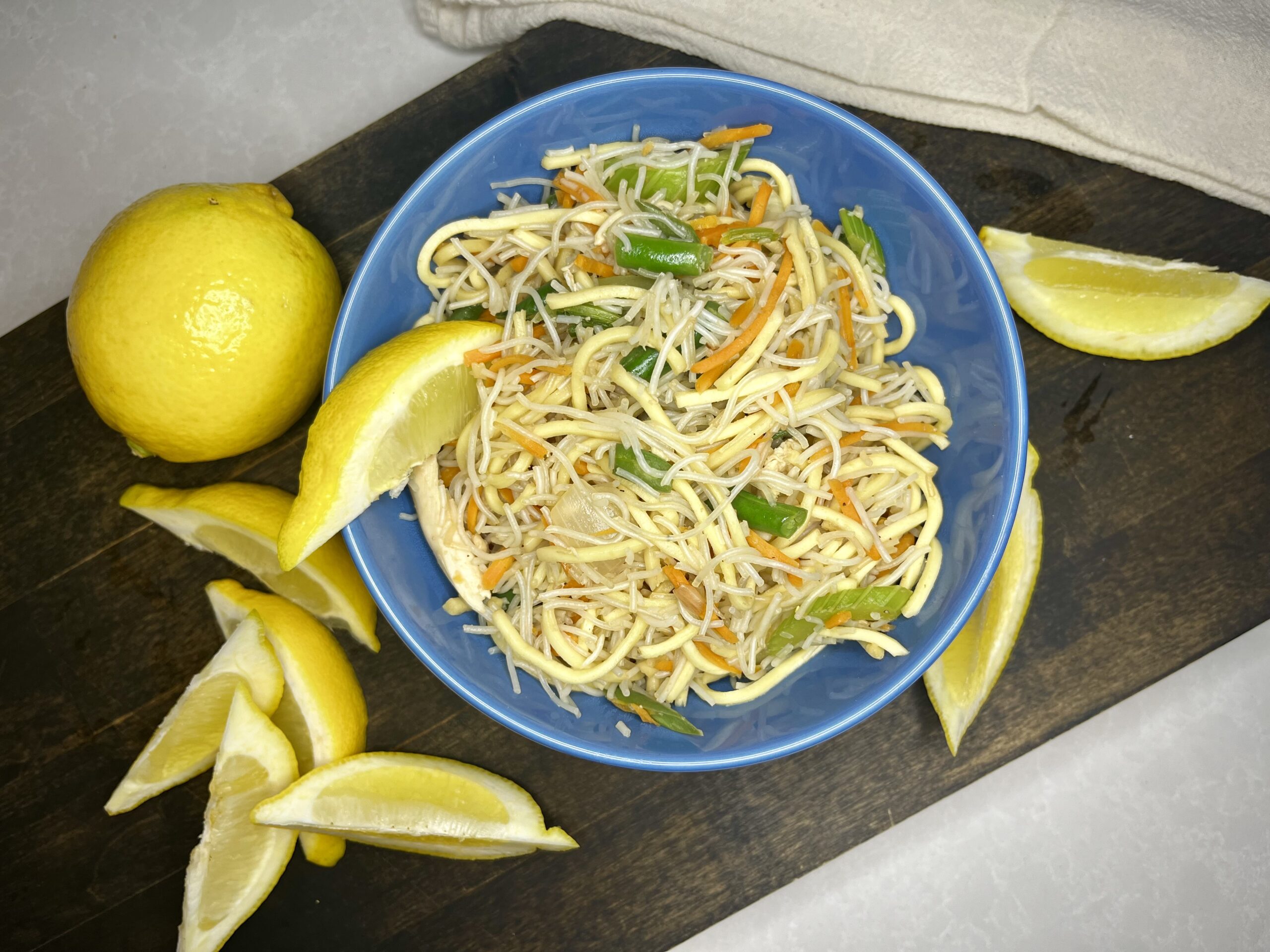 cooked pancit in a bowl with lemons