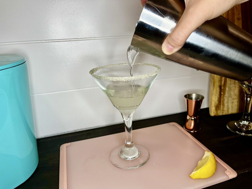 martini being strained into a glass