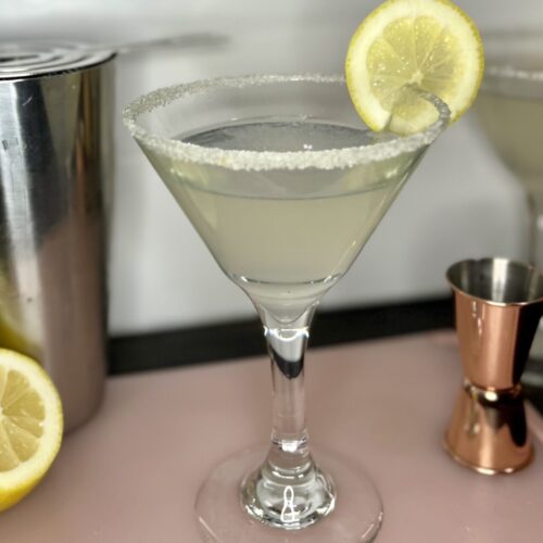 a lemon drop martini with a lemon wedge