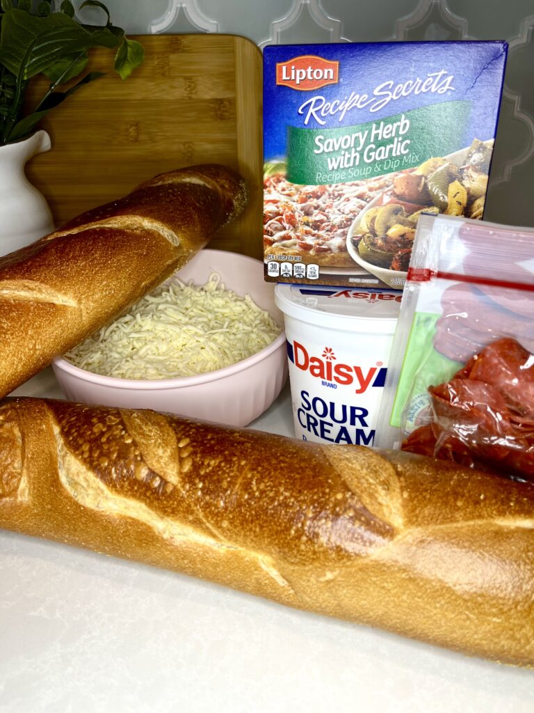 bread, pepperoni, cheese, sour cream and seasoning on a counter