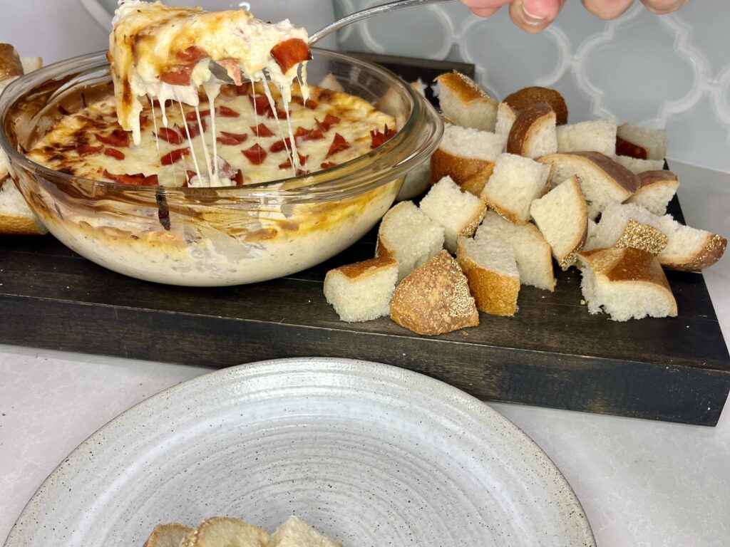 Pizza dip being scooped onto a plate