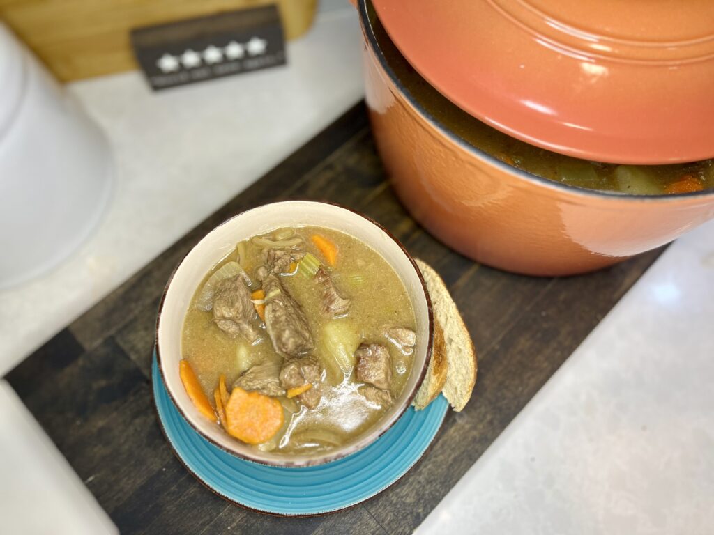 beef stew in a bowl next to pot