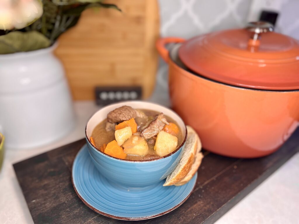 a bowl of beef stew with slices of bread