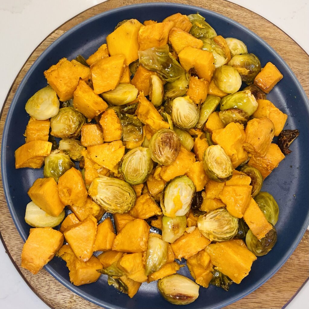 roasted sweet potatoes and brussel sprouts on a plate.
