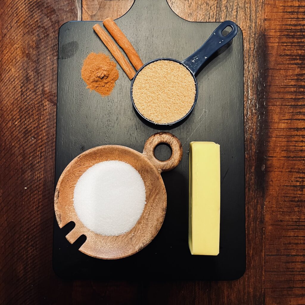 brown sugar, cinnamon, butter sugar, on a black cutting board