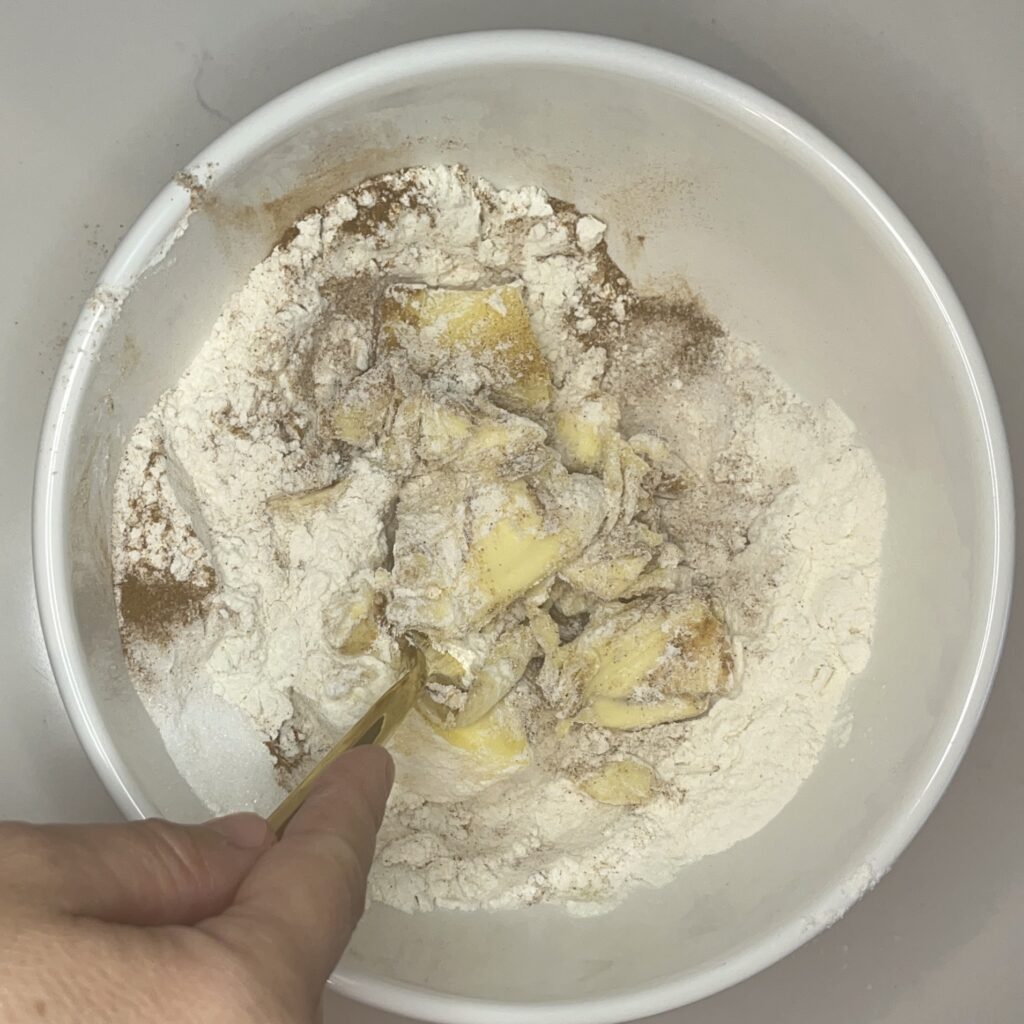  Mixing softened butter, flour, sugars and cinnamon with a fork in a large bowl