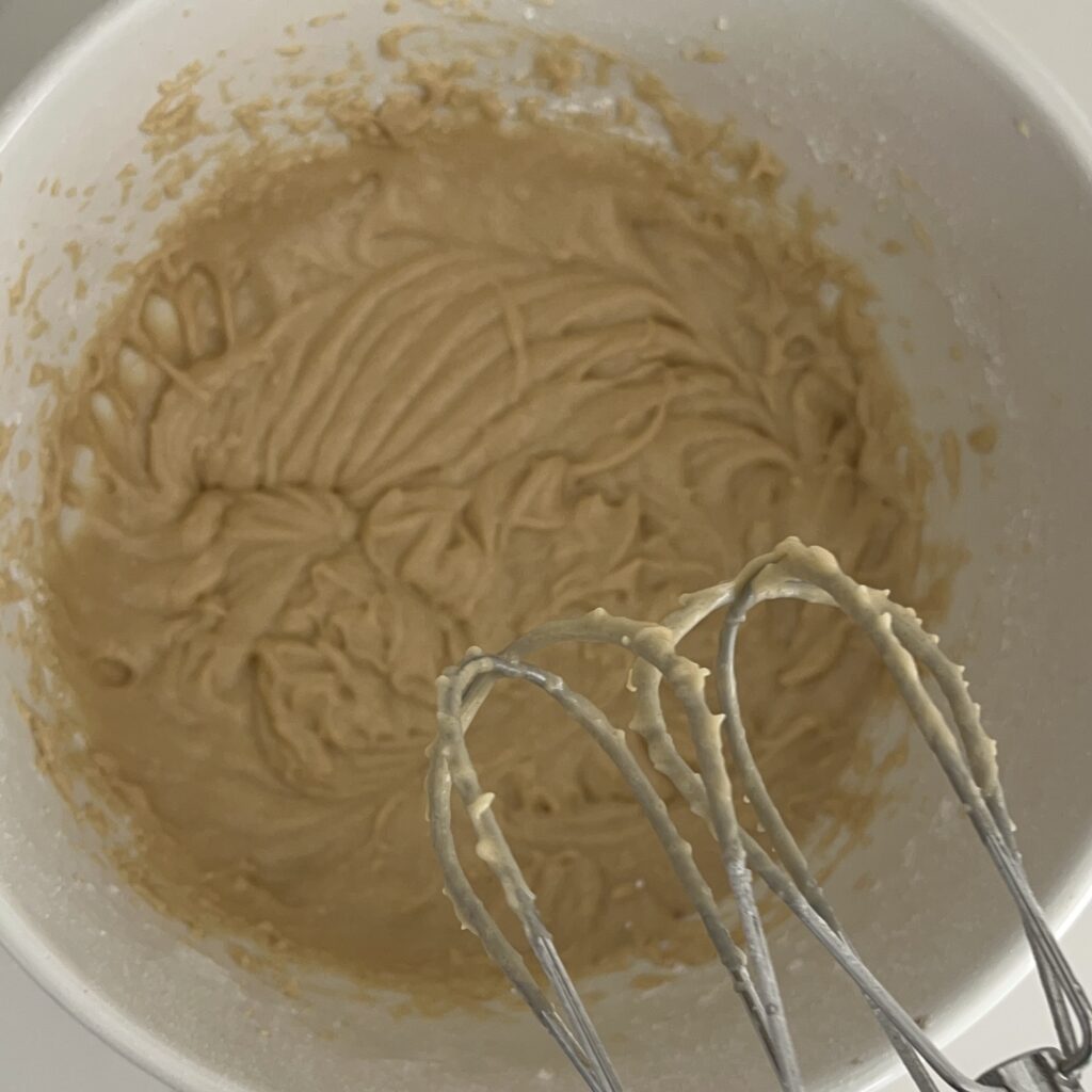 Whipped finished brown sugar icing in a large mixing bowl
