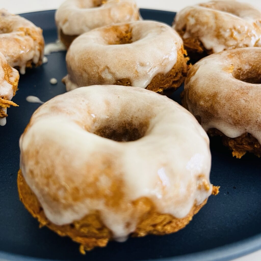 pumpkin donuts on a blue plate on the counter.