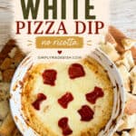 Hot white pizza dip with melted cheese and pepperoni slices served in a white bowl, surrounded by bread cubes on a wooden surface.