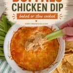 Buffalo chicken dip in a white bowl with a celery stick being dipped, served with tortilla chips on a wooden surface.