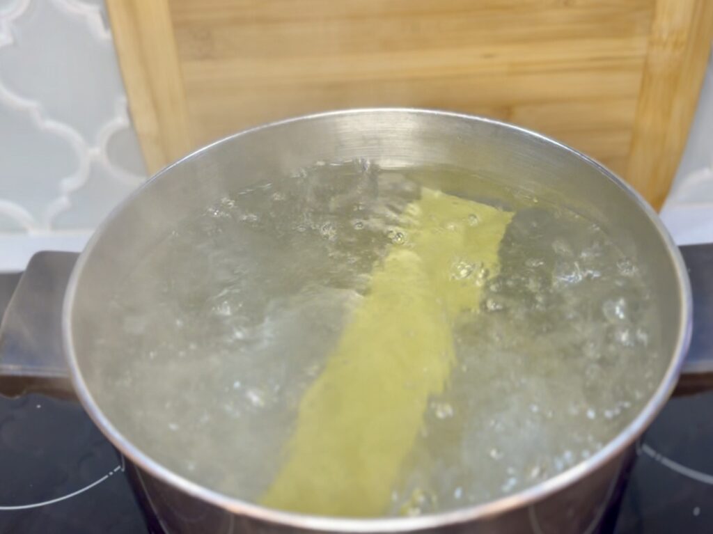 a lasagna noodle in a pot of boiling water