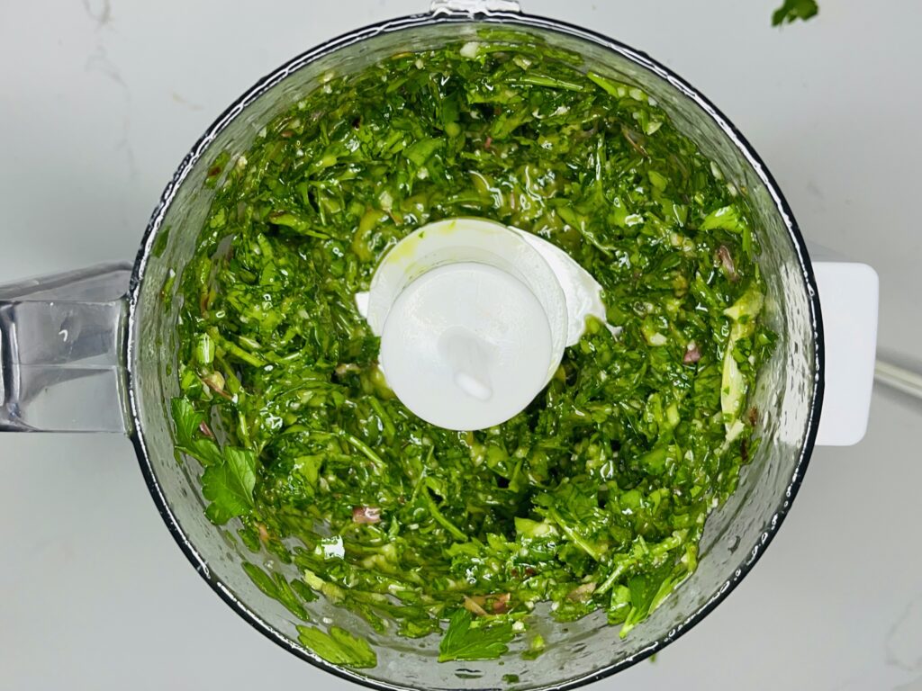 Pulsed and rough blend of chimichurri sauce in a food processer