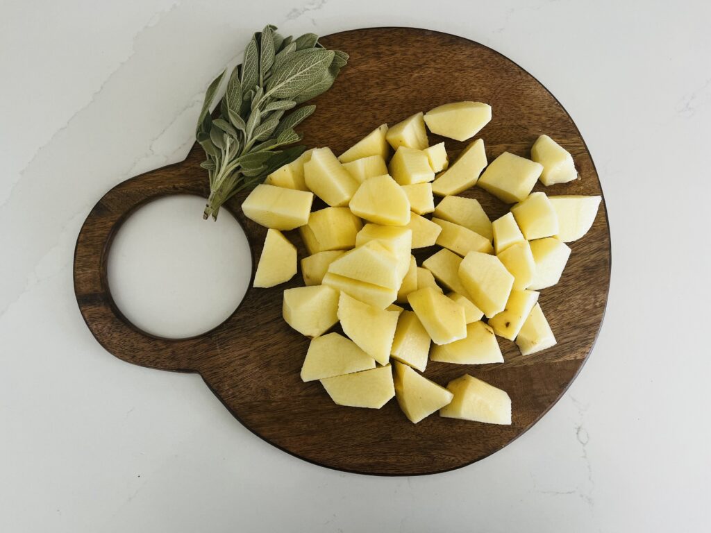 5 russet potatoes washed, peeled and cut into chunks on a cutting board