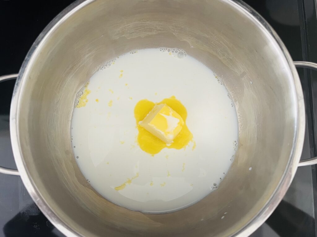 Butter and milk being heated in a pot on the stove
