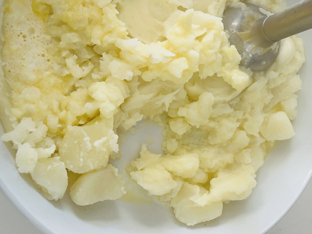 Using a hand mixer- mash the potatoes, butter and milk in a bowl