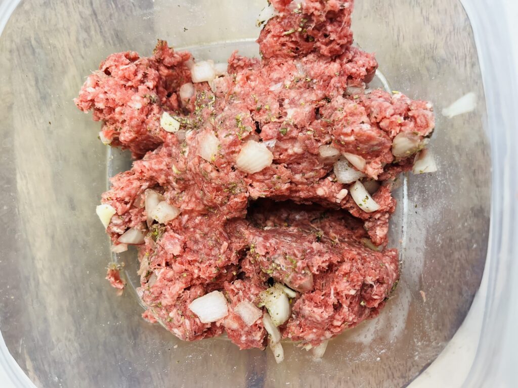 Mixed together, diced onions, garlic, salt and pepper, Italian seasoning and ground beef in a large mixing bowl