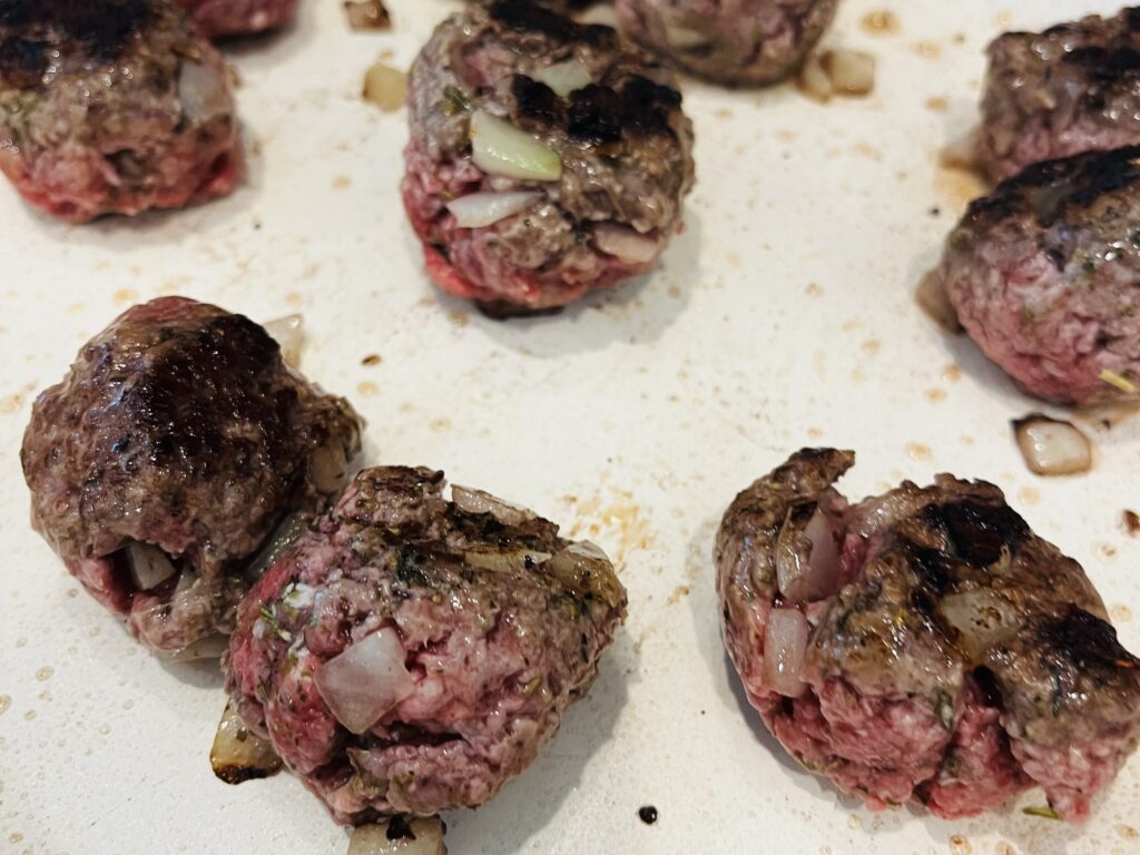 Browning meatballs in non-stick frying pan.