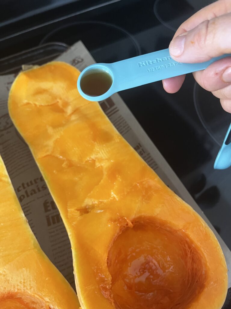 Adding maple syrup to squash on a baking sheet
