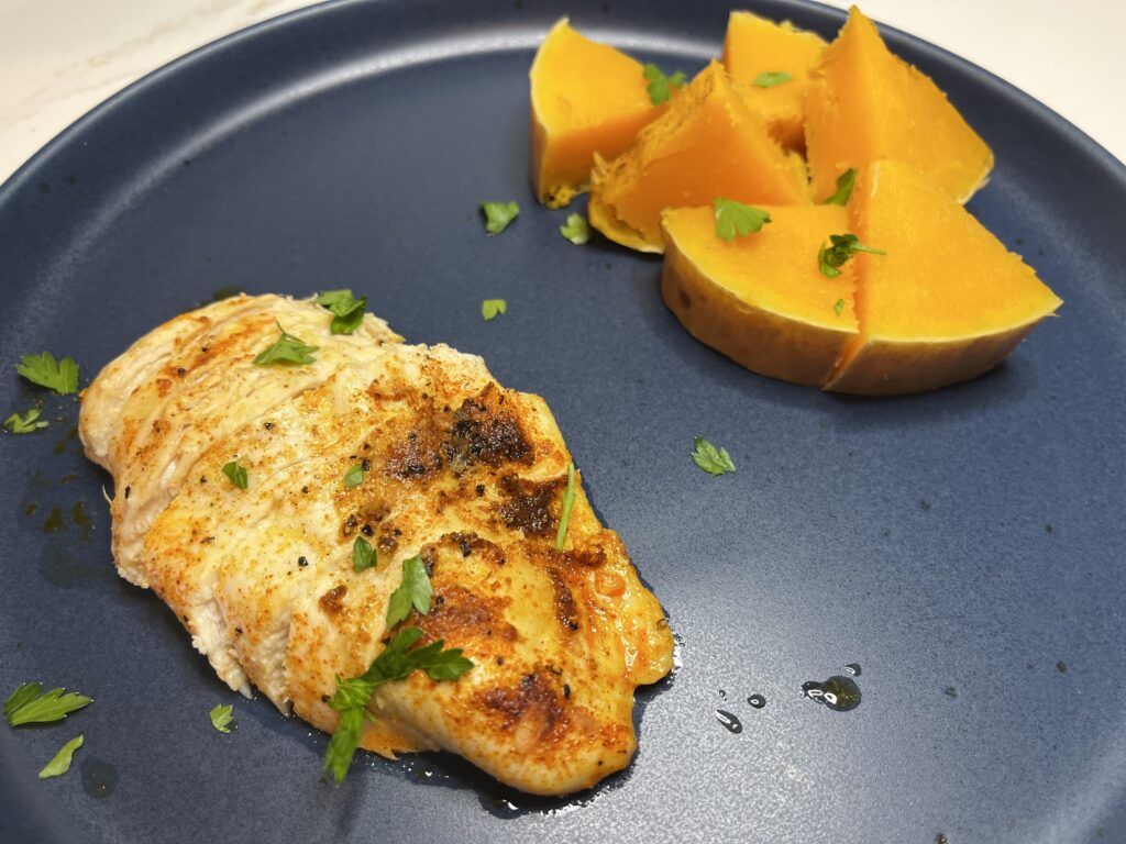 Oven roasted chicken breasts with a side of butternut squash on a plate