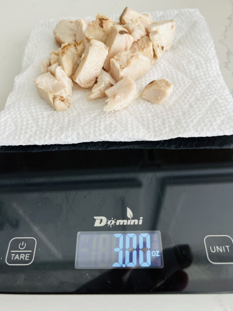 3 oz chicken breasts on a food scale on the counter