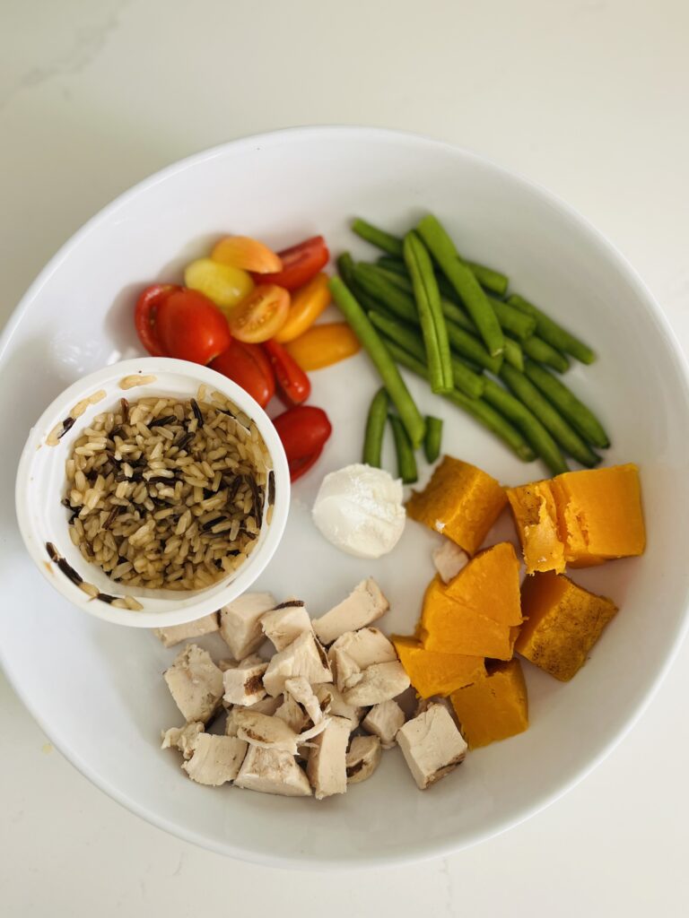 cooked minute microwave rice, green beans, cooked sweet potato, goat cheese, and tomatoes in a large wide bowl
