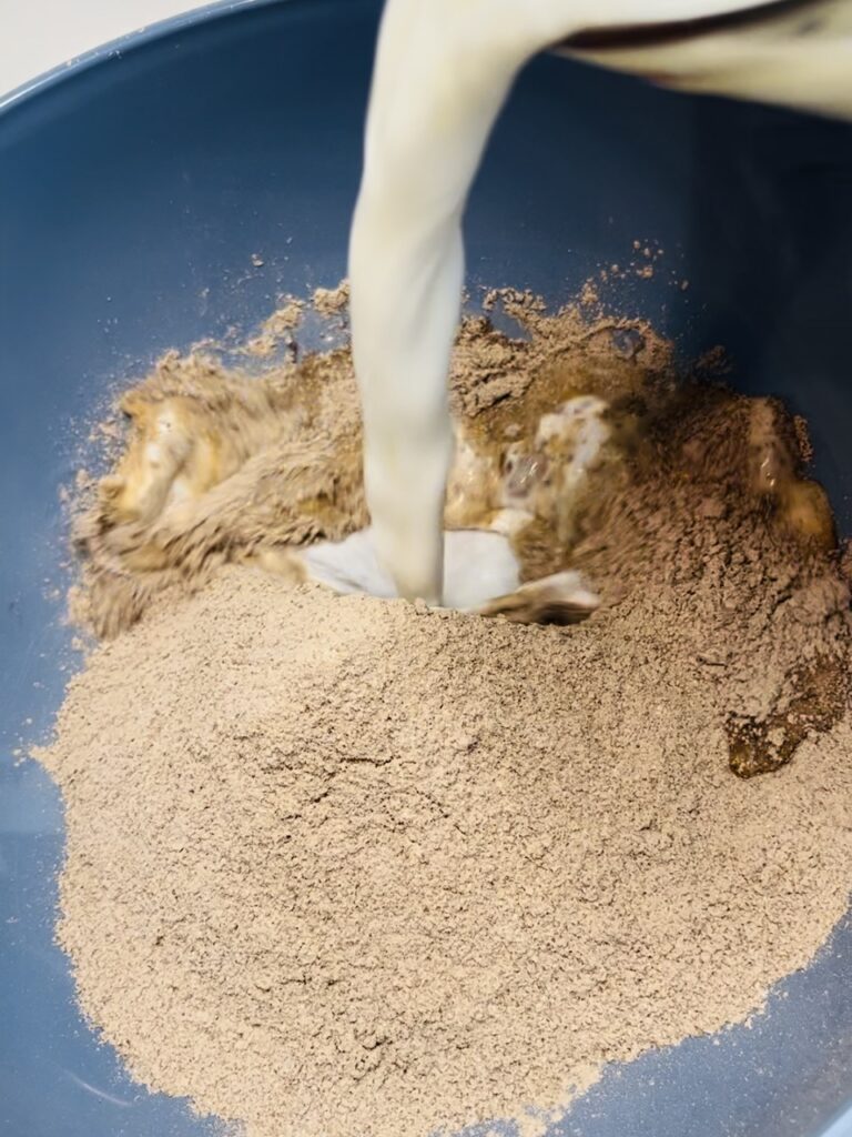 Pouring milk over top of dry pudding mix while in a bowl.