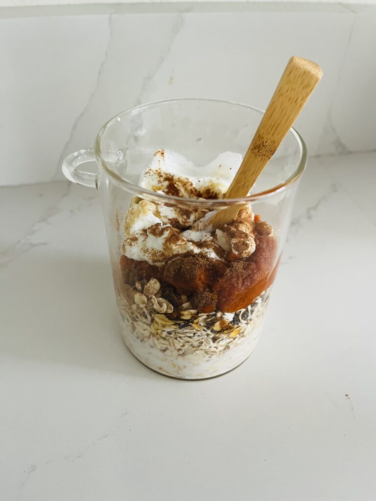 All ingredients in the glass jar about to be mixed with a spoon on the counter