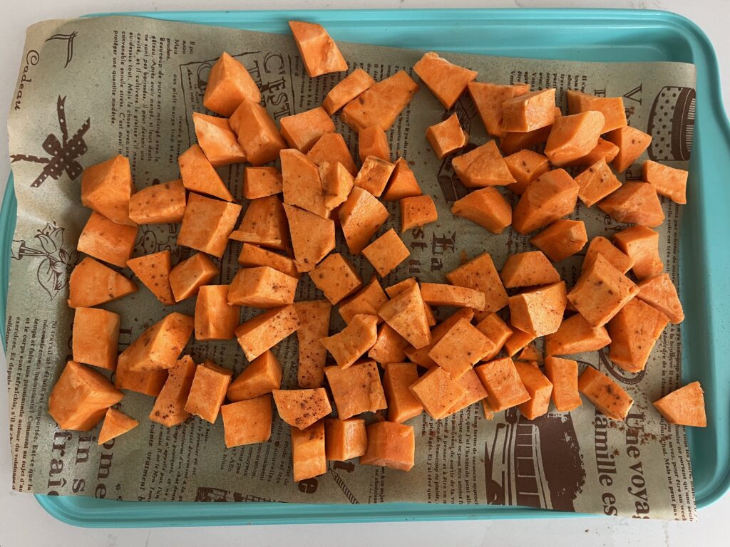 Sweet potato with olive oil and cinnamon on a baking sheet.
