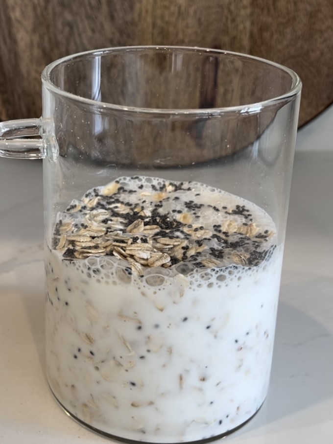 Oats. chia seeds and milk in a glass jar on counter