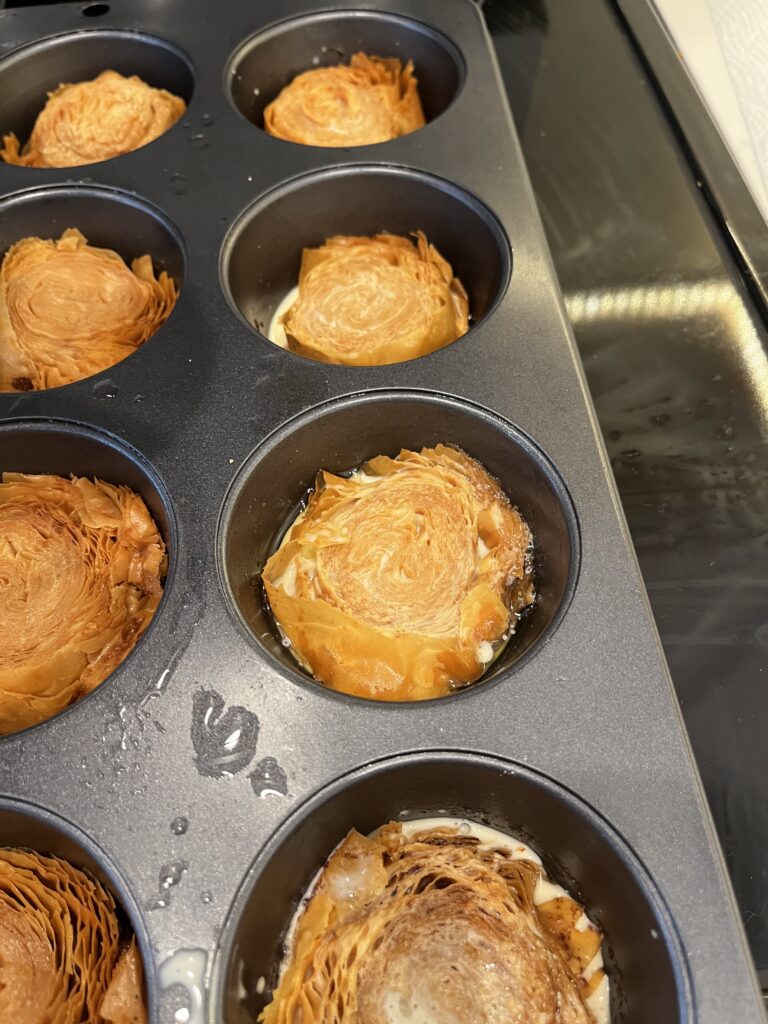 Soaked phyllo pieces with evaporated milk in muffin tin