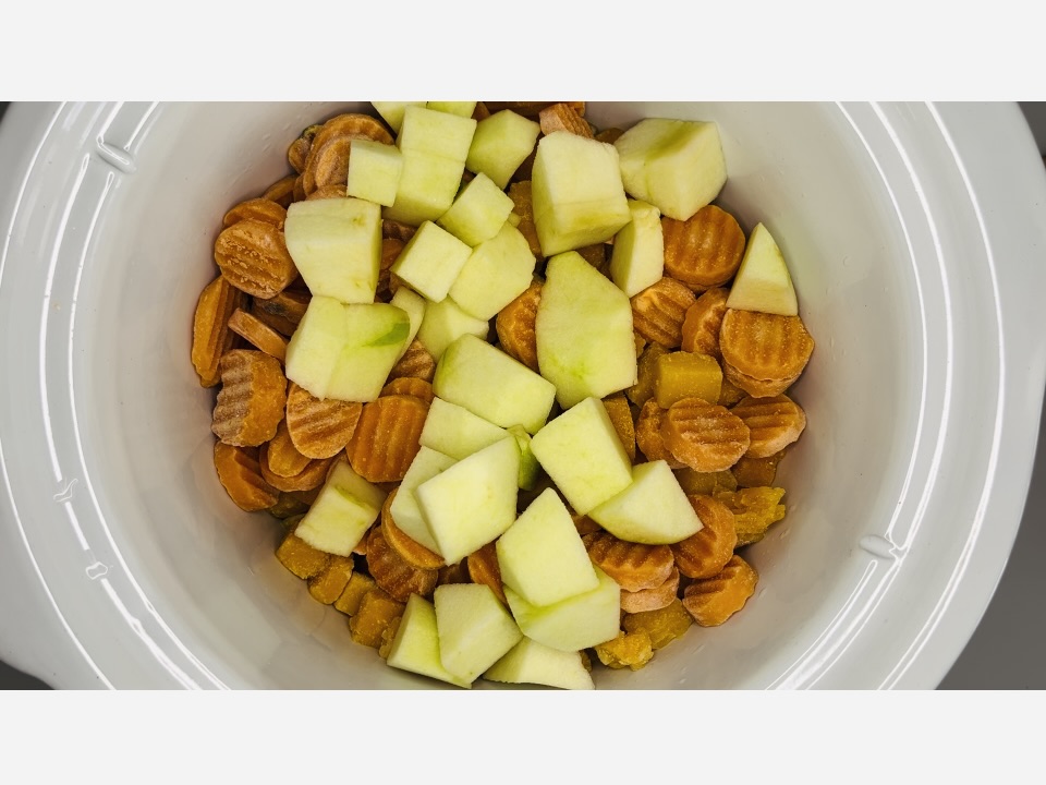 Frozen butternut squash, carrots and chopped up green apple in slow cooker.