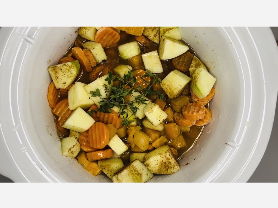 Adding sprigs of thyme to slow cooker.