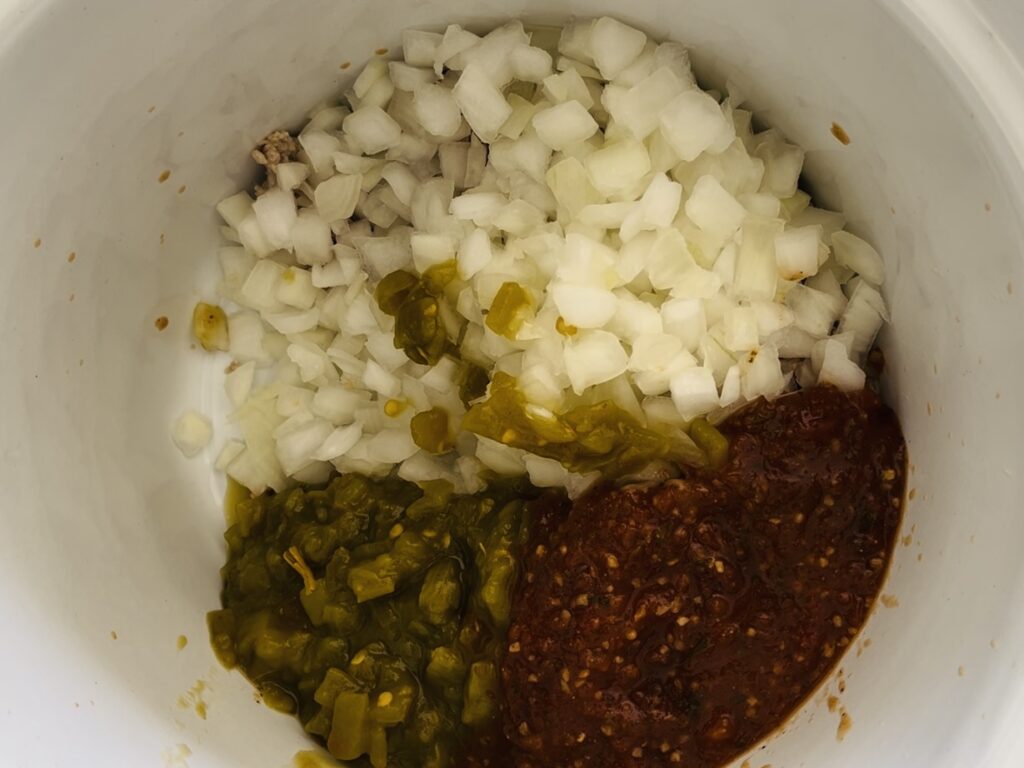 Onions, green chilies, salsa in slow cooker.