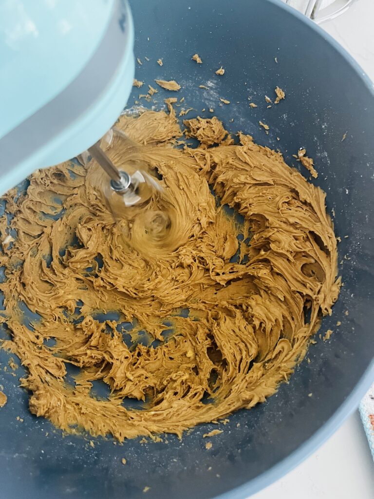 Using an electric mixer to combine ingredients in a mixing bowl