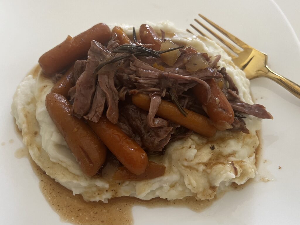 Roast Beef and over mashed potatoes on a plate