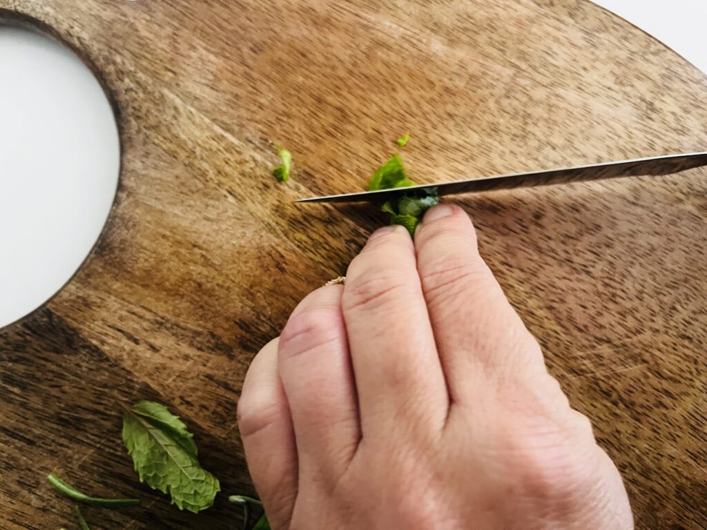 Cutting or mincing rolled mint leaves.