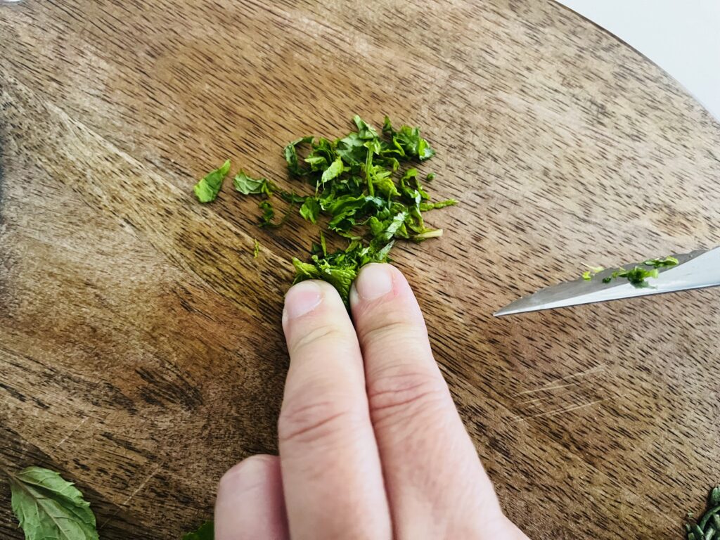 Using a knife to cut the mint leaves.