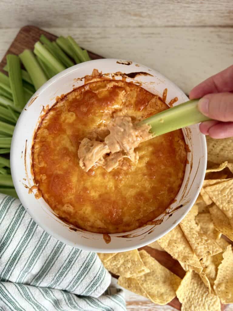 Creamy chicken pot pie dip with melted cheese, served with celery sticks and tortilla chips for dipping – easy party appetizer, comfort food, and snack options.