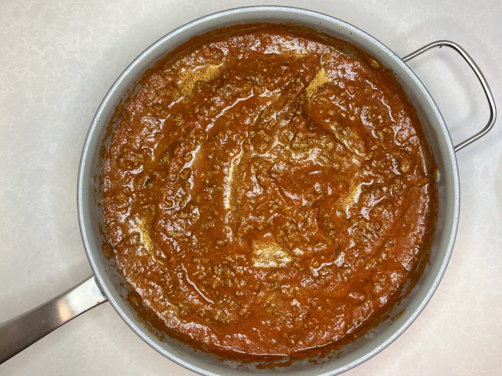 red sauce and browned ground beef in a pan