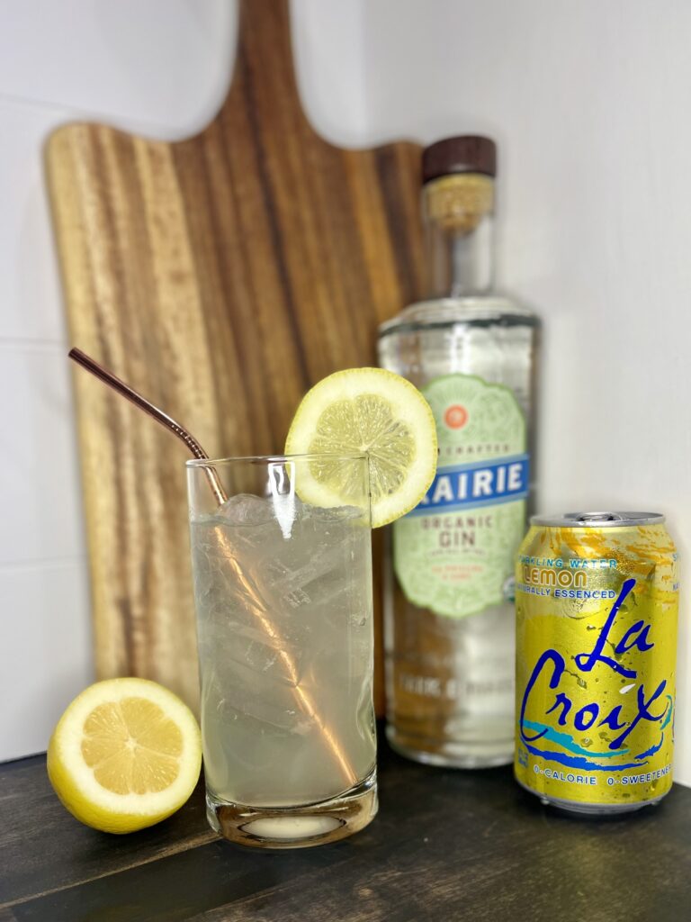 A tom collins cocktail with seltzer water, gin, and a lemon